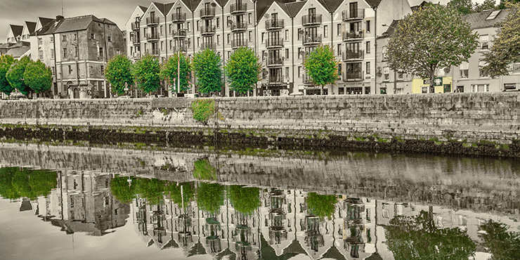 coloured houses in cork with reflection in river lee